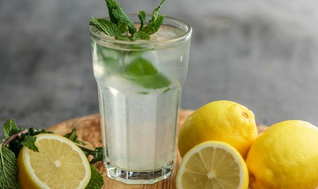 sklenice s citrónovou vodou a citronami s mátou